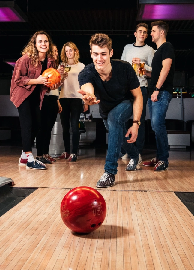 Eine Gruppe Erwachsener beim Feiern und Bowling spielen