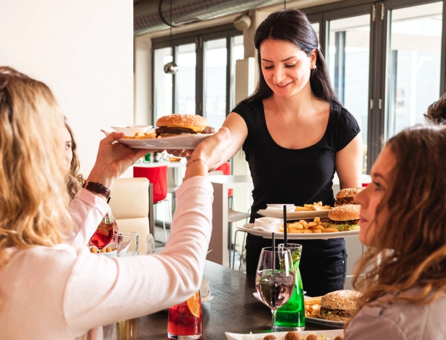 Die Bedinung serviert die leckeren Burger